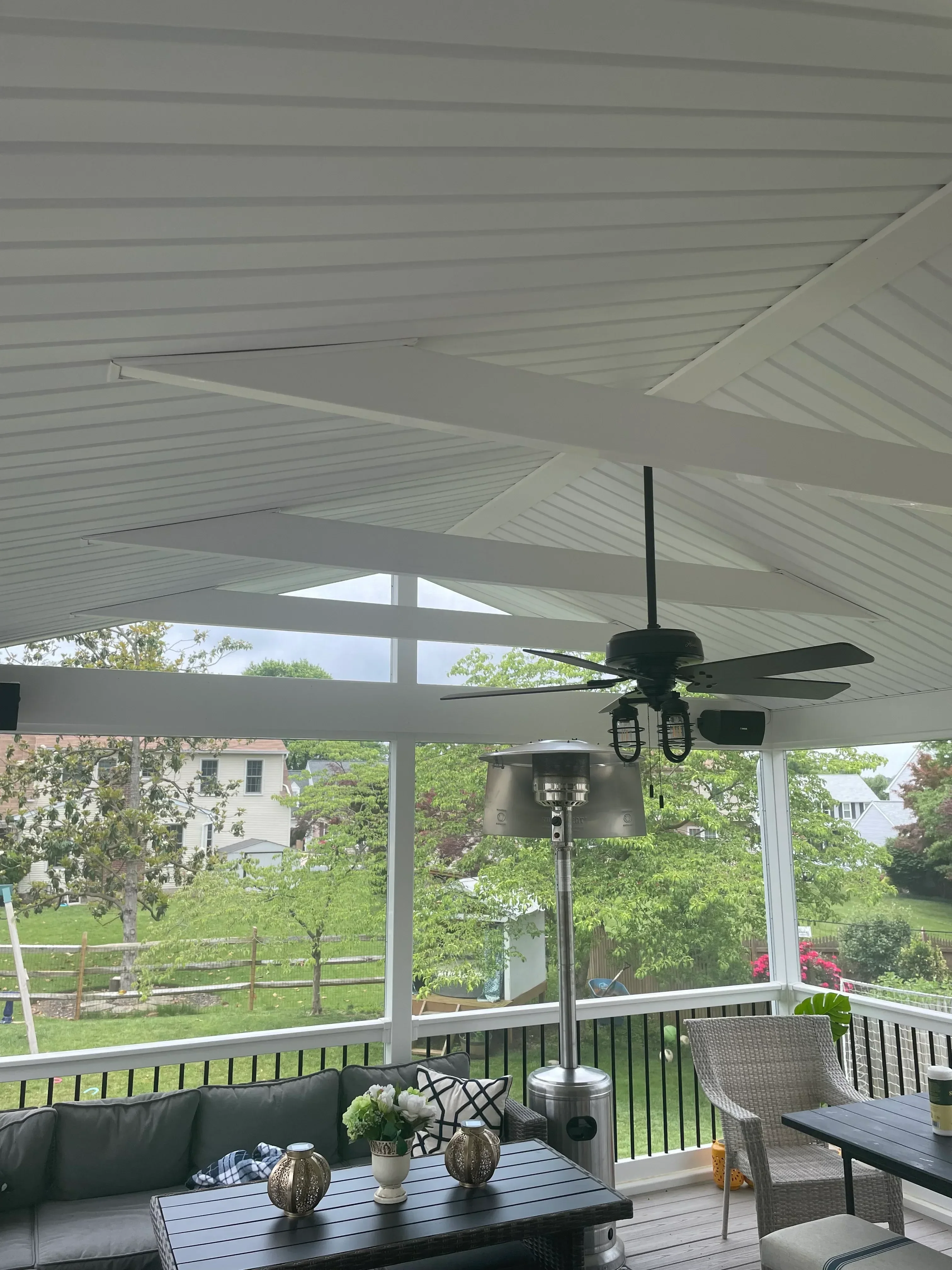 Composite deck with horizontal boards, white railings, ceiling fan, and integrated outdoor lighting