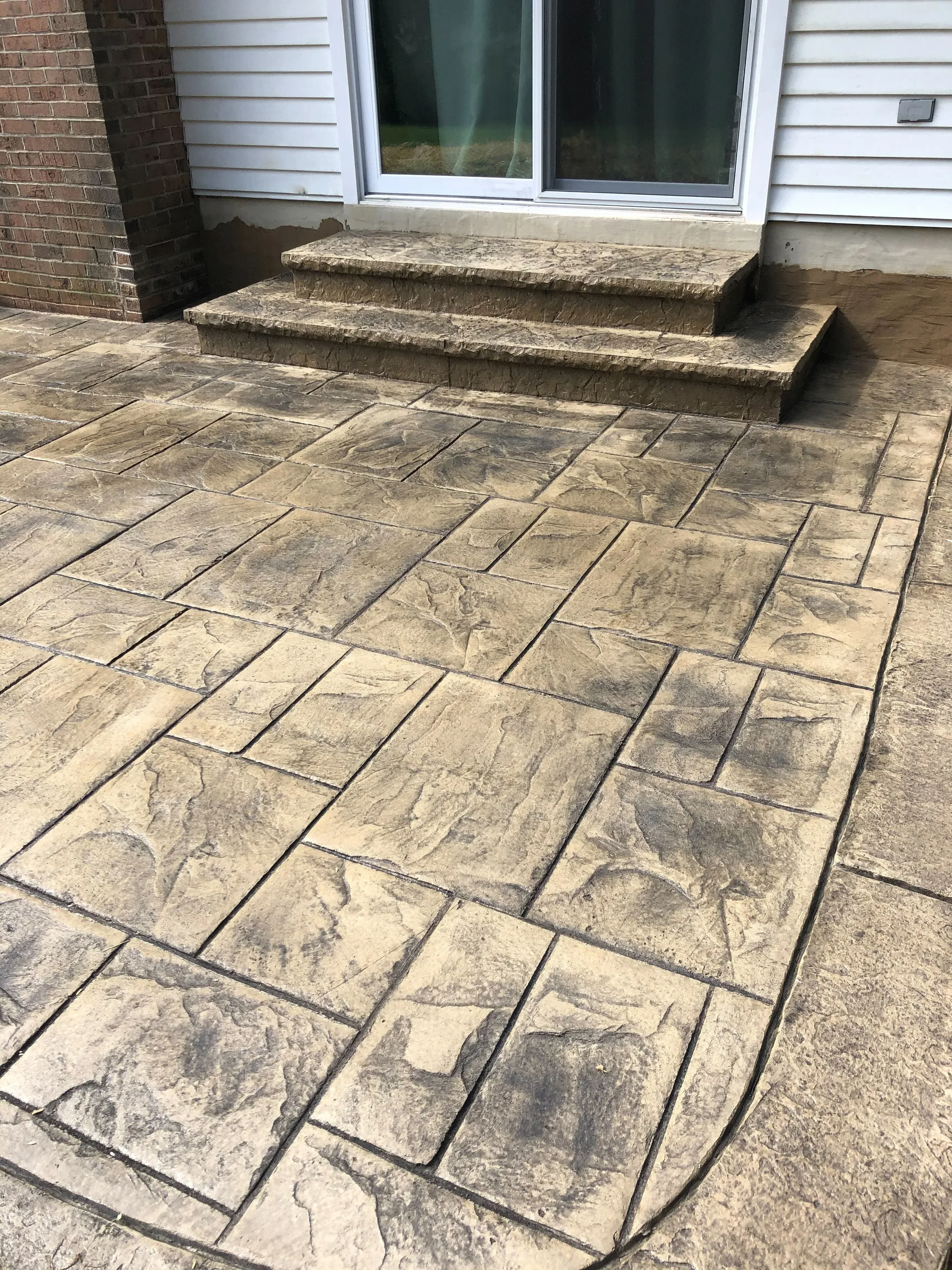 Stacked stone veneer wall with ashlar pattern and mortar joints, tan and gray tones