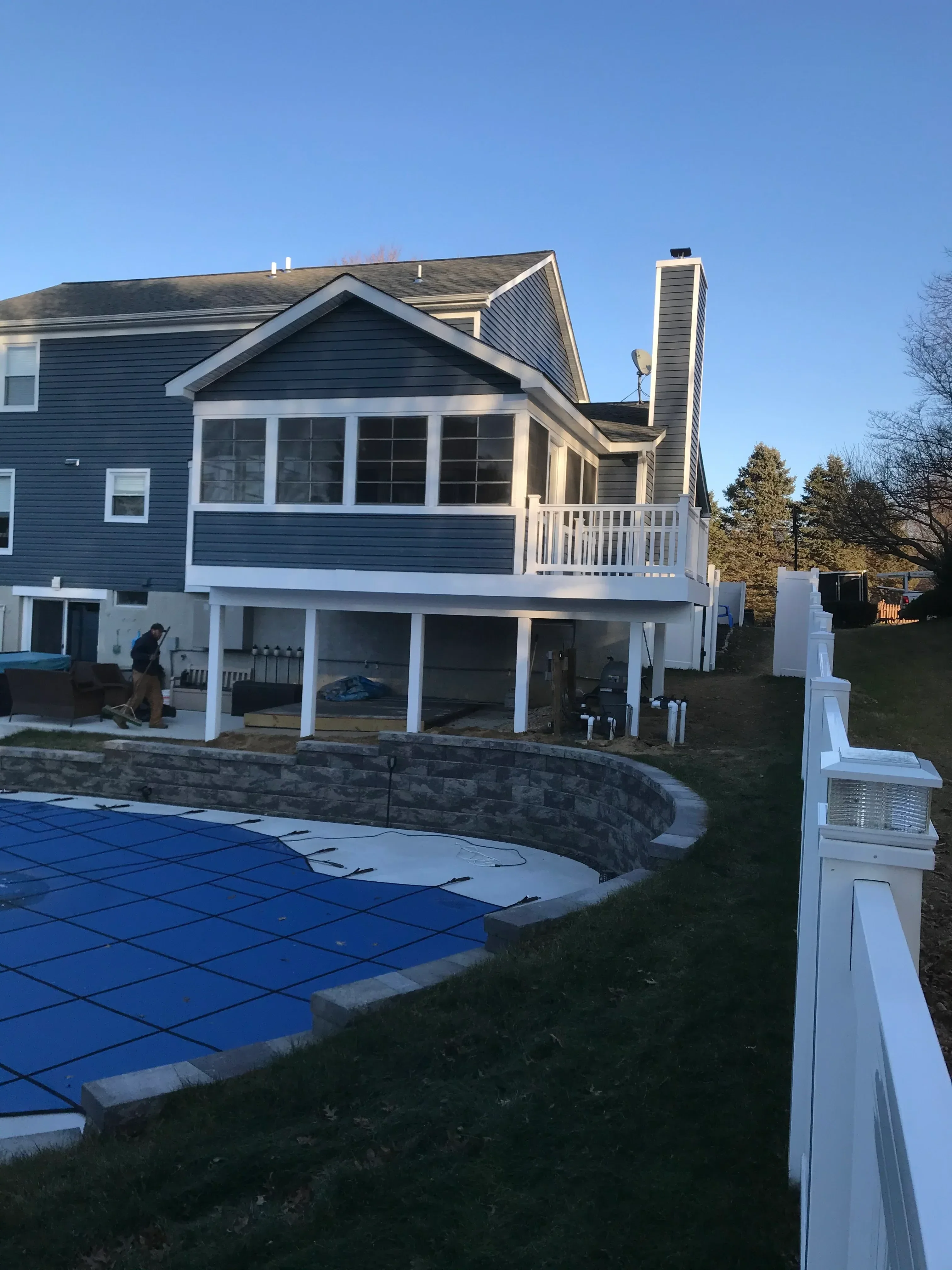 Metal-sided residential addition with corrugated roofing, white trim, and HVAC units
