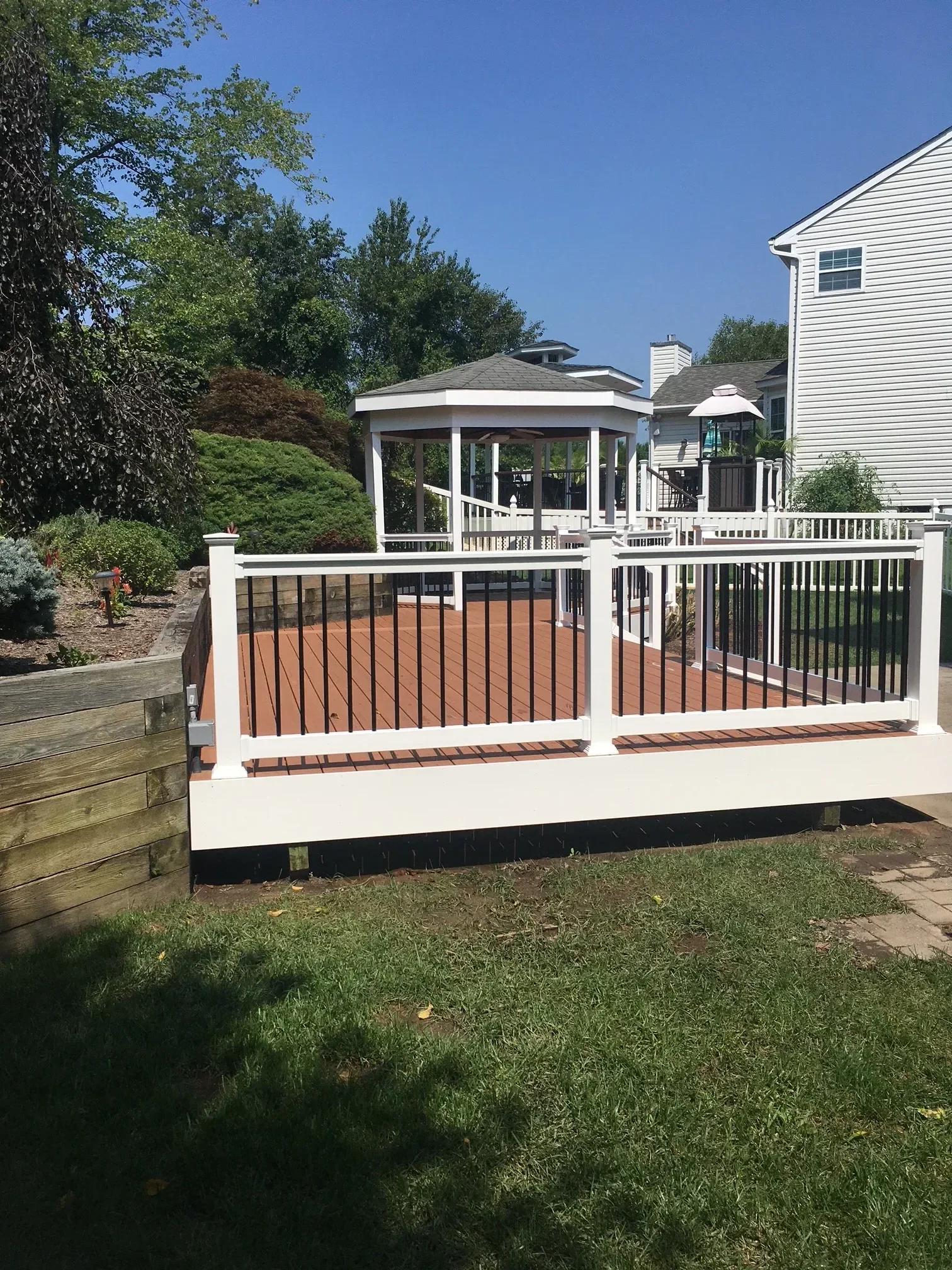 Composite deck with horizontal metal railings, white trim, and integrated planters