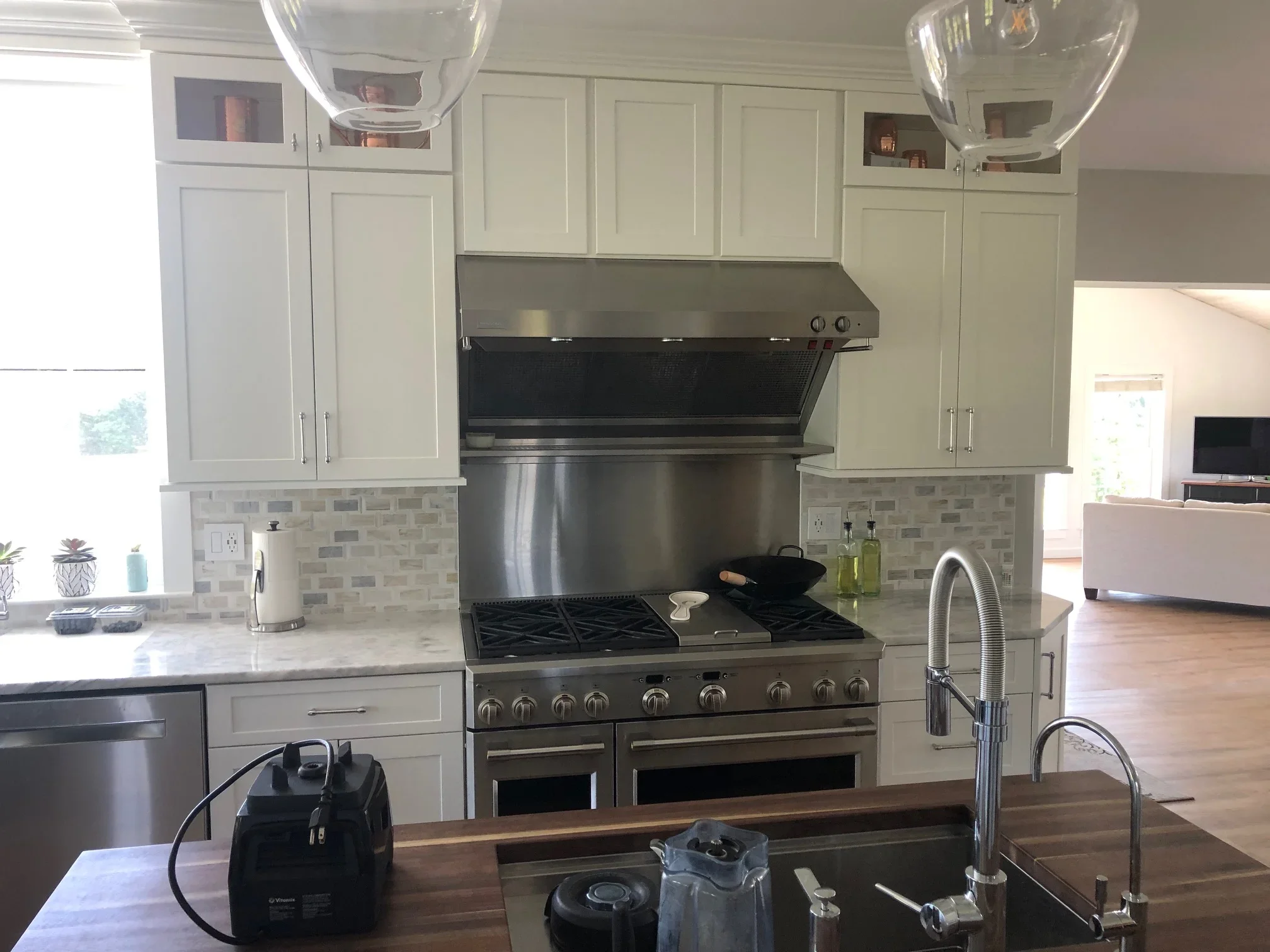 Kitchen with cream cabinetry, stainless steel range, white quartz counters, and subway tile backsplash