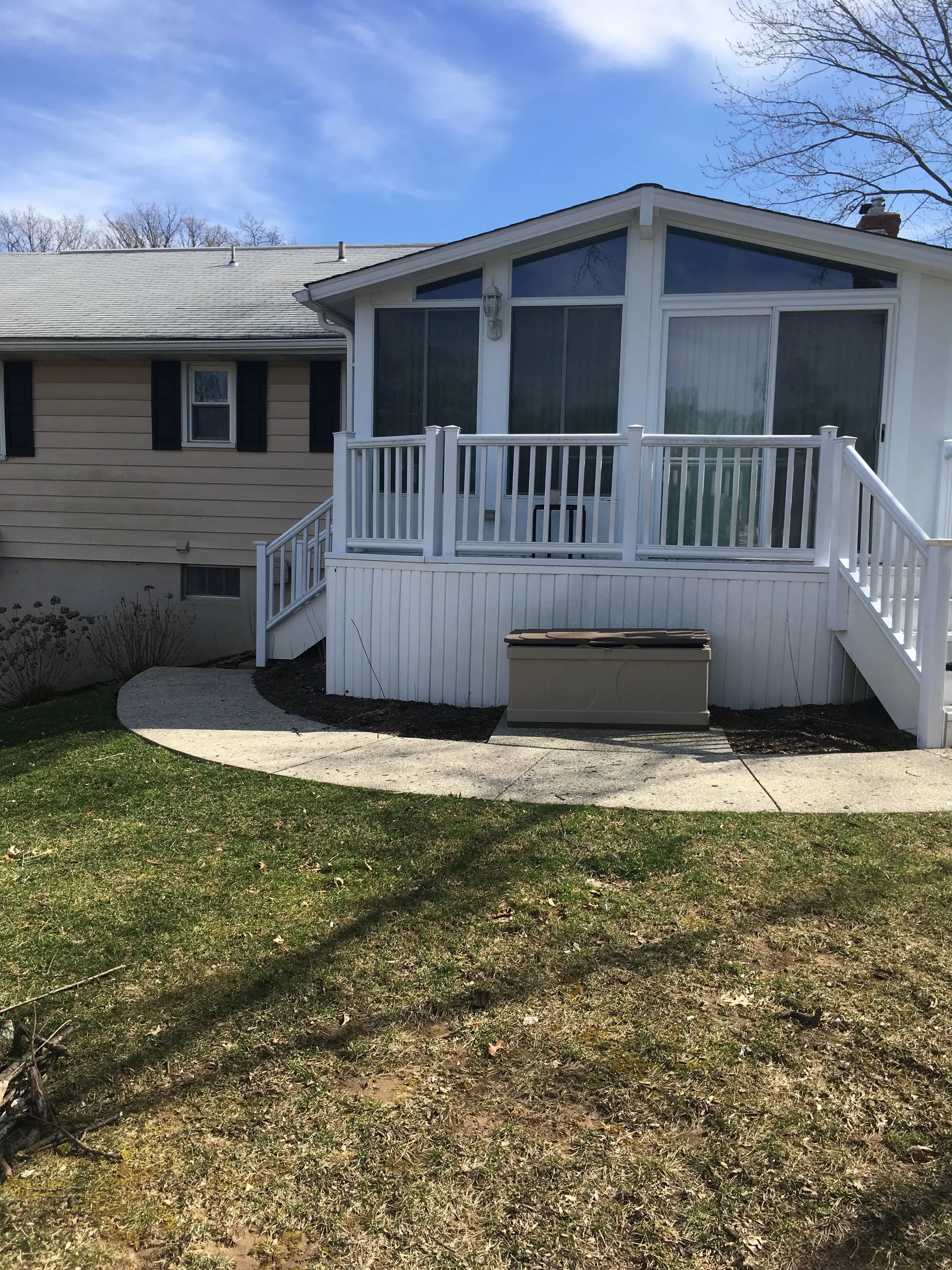 Light gray vinyl siding with replacement windows and louvered vents on residential home exterior