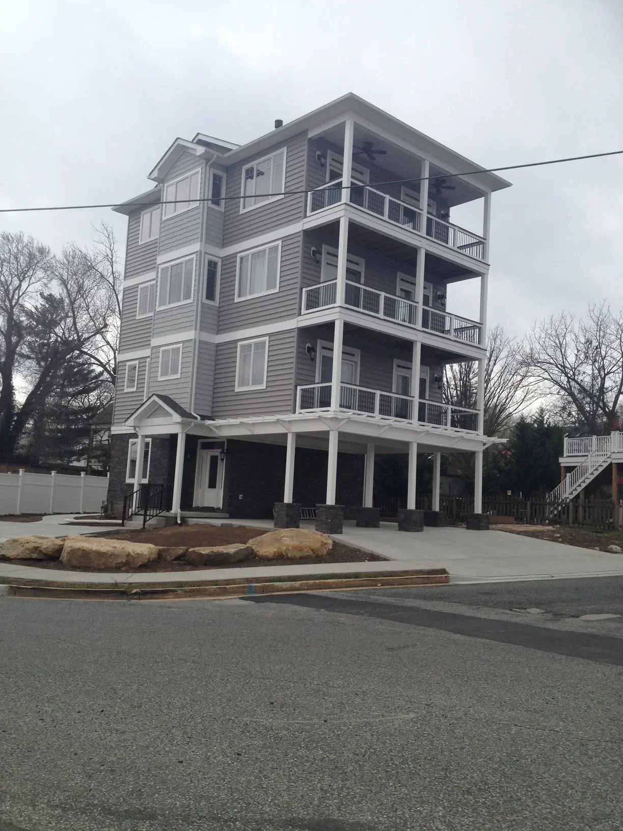 Three-unit residential building with metal siding, windows, and exterior metal staircase